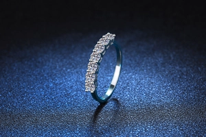 Macro detail of a 925 sterling silver half eternity ring with seven round moissanite stones