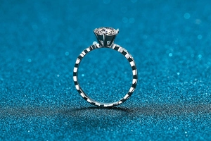 Gros plan sur la bague moissanite à six griffes avec anneau texturé géométrique alvéolé