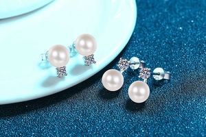Detailed close-up of S925 silver stamp on pearl stud earrings with sparkling moissanite