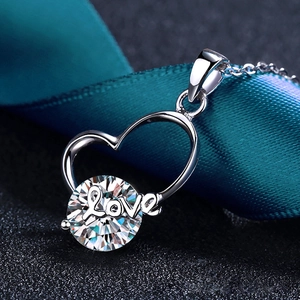 Makroaufnahme von Herzanhänger aus Silber mit großem Moissanit und Love-Gravur