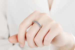 Close-up of seven round-cut sparkling moissanite stones set in a silver 925 band