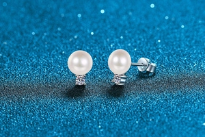 Close-up of S925 sterling silver butterfly backs and white round pearl earrings detail
