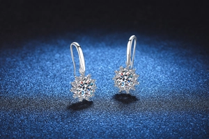 Dettaglio di orecchini a girasole in argento con pietre moissanite su sfondo blu scuro