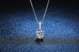 Macro shot of s925 silver necklace featuring a six-prong moissanite pendant with side stones