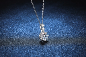 Macro shot of 925 silver moissanite necklace featuring a classic six-prong setting on deep blue