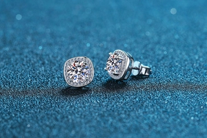 Macro shot of princess-cut moissanite stud earring on dark blue textured background