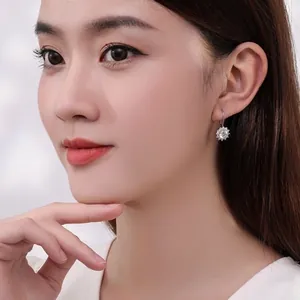 Boucles d'oreilles classiques tournesol en argent S925 et moissanite sur un modèle