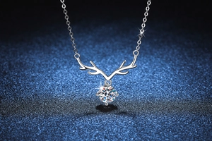 Macro view of sterling silver reindeer necklace with round brilliant moissanite pendant