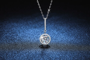 Macro shot of 925 silver necklace featuring a round moissanite pendant on a dark background