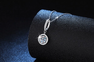 Close-up of S925 silver moissanite pendant with halo diamonds on a black pedestal