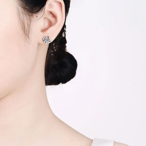 Elegant S925 sterling silver four-leaf clover moissanite earrings worn by a model