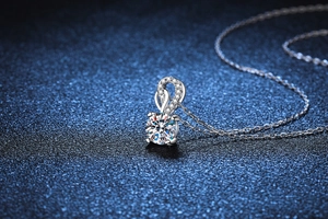 Macro view of 1 carat round moissanite pendant with twisted pavé loop and 4-prong setting