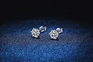 Macro view of six-prong moissanite stud earrings featuring brilliant round-cut stones