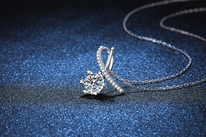 Vue macro d'un pendentif moissanite 1 carat avec nœud en argent et détails de ruban