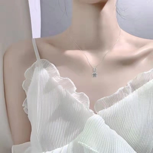 Elegant S925 sterling silver necklace with a 1ct round moissanite pendant worn by a model