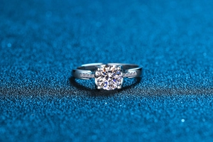 Macro shot of a four-prong set moissanite diamond ring with side stone accents