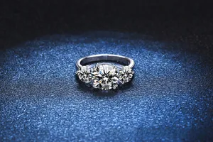 Detailed view of luxury three-stone ring with 3 carat round brilliant moissanite