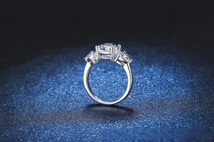 Macro side view of luxury 3-carat three-stone s925 silver ring on navy background