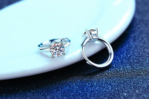 Macro shot of 925 sterling silver huggie earrings with four-prong round cut moissanite