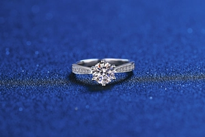 Detailed macro view of a six-prong moissanite ring with side-stone micro-pave setting