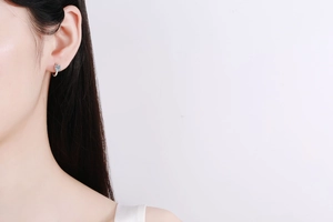 Close-up of S925 sterling silver moissanite stud earring worn on model's ear