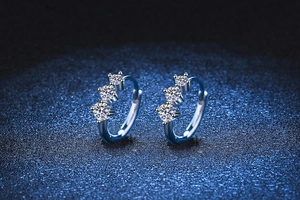 Macro detail of S925 silver hoop earrings with three brilliant-cut Moissanite stones