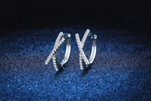 Detailed view of silver bow-shaped sterling silver earrings with pavé moissanite stones