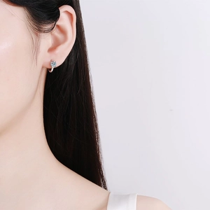 Classic S925 sterling silver four-prong moissanite stud earrings on a female model