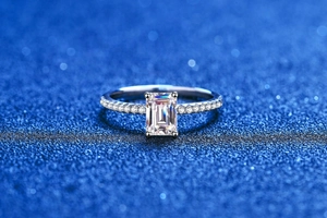Macro shot of an emerald-cut moissanite ring with pavé-set side diamonds in S925 silver