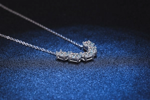 Gros plan du collier en argent S925 avec cinq pierres moissanite rondes en pendentif courbé