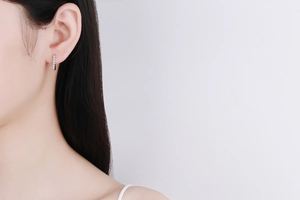 Close-up of S925 sterling silver hoop earrings with pavé moissanite on a female model