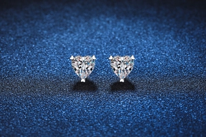Close-up of heart-cut moissanite stud earrings in a three-prong S925 silver setting