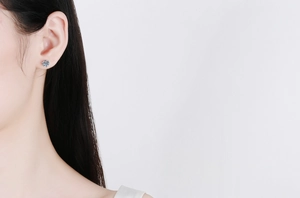 Classic Moissanite stud earring featured in a minimalist silver setting on a female model