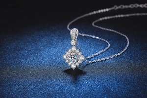 Macro d'un pendentif en moissanite et argent sterling sur fond bleu foncé texturé