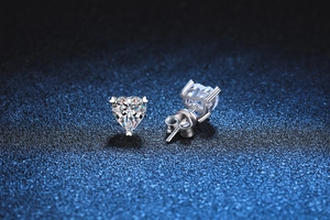 Macro shot of heart-cut moissanite earrings with 3-prong silver setting and butterfly back