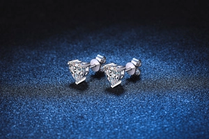 Macro shot of heart-cut moissanite earrings in s925 silver on deep blue background