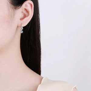 Elegant S925 sterling silver moissanite drop earrings worn by a model in soft light