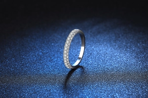 Macro shot of s925 silver moissanite row ring with sparkling gems on blue background