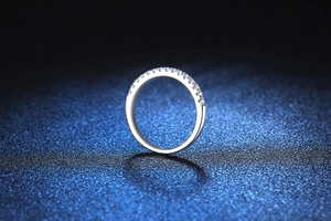 Macro shot of s925 silver moissanite eternity band on deep blue textured background