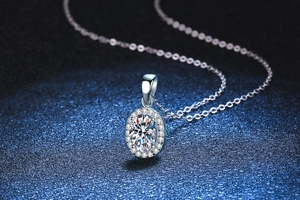 Detailed view of large oval moissanite halo pendant on a silver box chain necklace