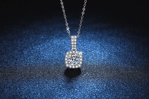 Macro shot of 1ct moissanite pendant with halo setting on a luxury dark blue background