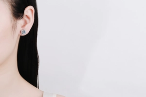 Close-up of s925 silver square moissanite stud earring worn on a female ear