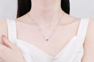 Gros plan d'un collier en argent moissanite sur un modèle montrant le serti à six griffes