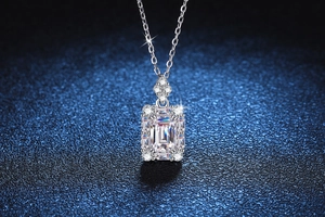 Gros plan du pendentif en moissanite taille émeraude avec halo sur chaîne en argent