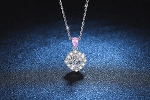 Vue macro d'un collier en argent avec pendentif diamant carré et pierre rose goutte