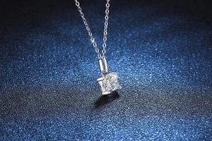 Détail d'un pendentif en moissanite taille princesse sur une chaîne en argent fin