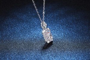 Détail macro du pendentif moissanite taille émeraude sur chaîne argent s925 bleu pailleté