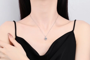 Close-up of a S925 silver heart pendant necklace with shimmering Moissanite on a model