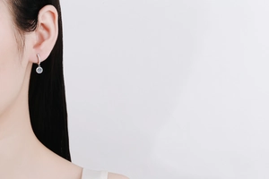 Close-up of S925 sterling silver drop earrings with moissanite stones on model's ear