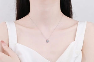 Detail shot of a s925 silver necklace with blue-green and pink heart-cut gems on neck